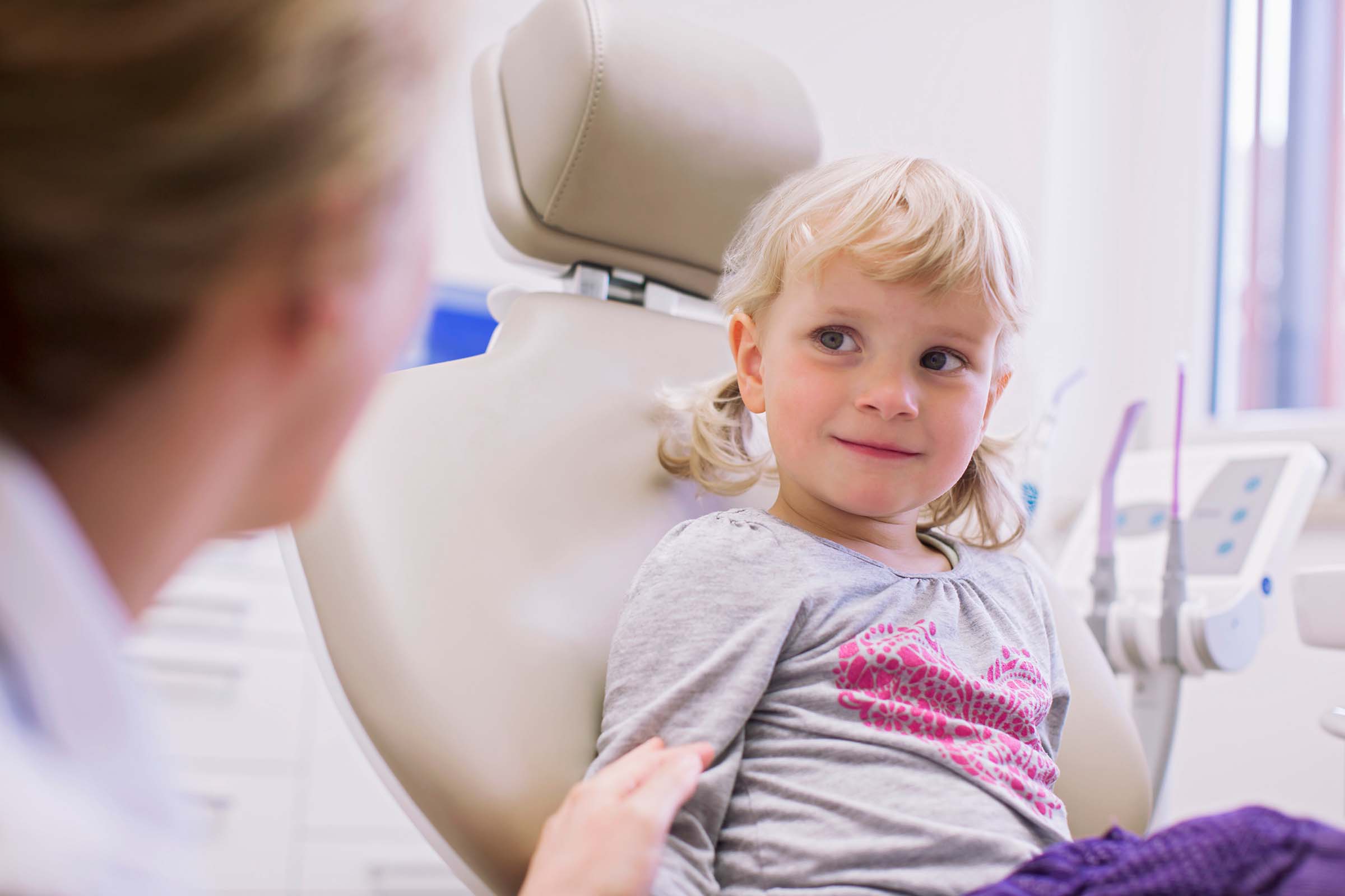 Young girl comforted by her kind dentist Young girl receiving gentle dental care, comforted by dentist. Family dentistry services for children.